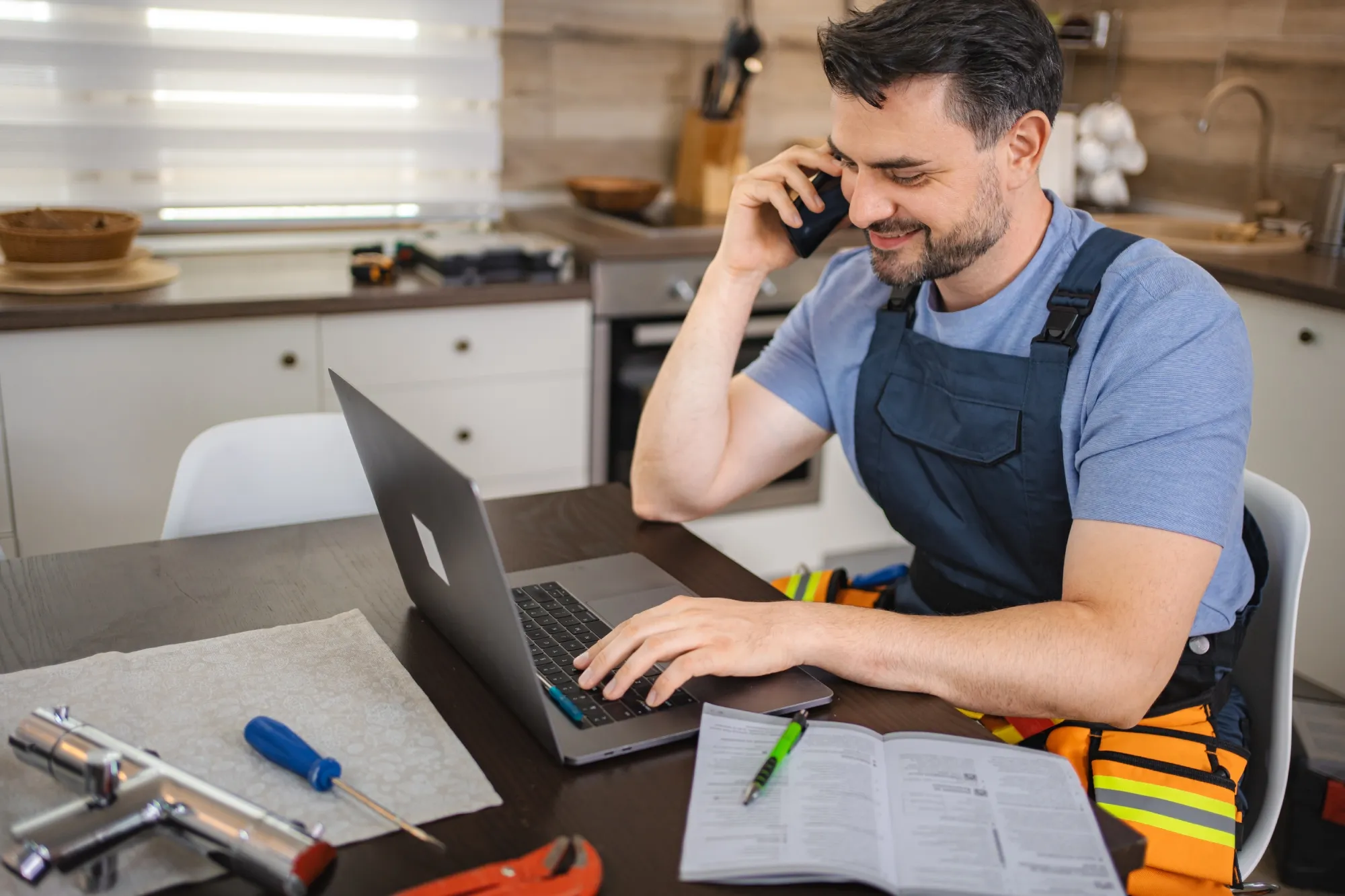 A laptop with a contact form on a table full of tools.