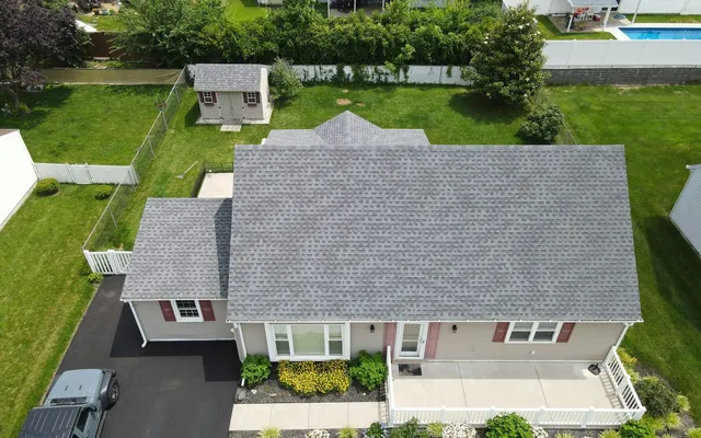 Aerial view of a suburban house with a newly shingled gray roof